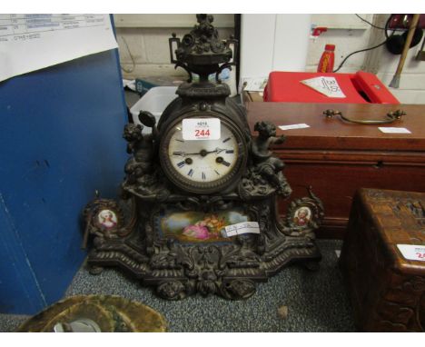 FRENCH GILT METAL MANTEL CLOCK WITH MOUNTED CHERUBS, CAST DECORATIONS AND PORCELAIN PANELS 