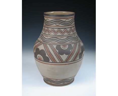 A large Carter, Stabler Adams Poole pottery vase, the unglazed baluster form painted with brown and terracotta slips, impress