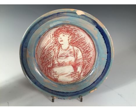 Quentin Bell, a Fulham Pottery plate, centrally incised with a woman reading or singing from a book to a banded blue border, 