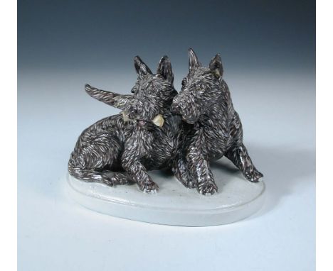 A Goldscheider model of two Scotties, the seated dog holds a bone whilst the other stands behind, impressed marks 17 x 21cm (