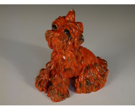 Ida Meisinger for Goldscheider, an orange glazed model of a terrier, seated, printed and impressed marks 20cm (8in)  