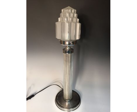 An Art Deco style table lamp, the moulded frosted glass shade above a glass rod clad column and circular foot 56cm (22in)  