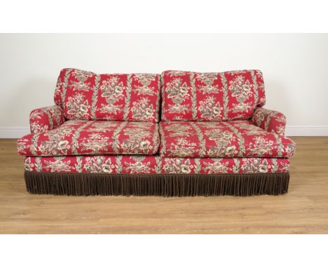 A THREE SEAT SOFAUpholstered in a brick red floral upholstery print with tasselled fringe, 210cm wide; 78cm highCondition rep