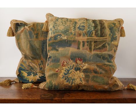 A PAIR OF FLEMISH VERDURE TAPESTRY FRAGMENT CUSHIONS (2)Probably late 17th/ early 18th Century With braided borders and tasse