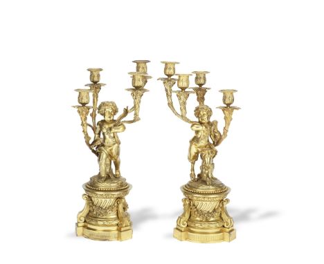 A pair of late 19th century French gilt bronze figural four light garniture candelabrain the Louis XVI style, the figures in 