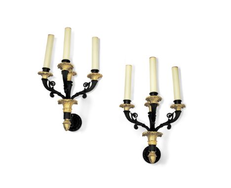 A pair of French black patinated and gilt bronze three light wall appliquesin the Restauration stylethe multi-scrolling reede