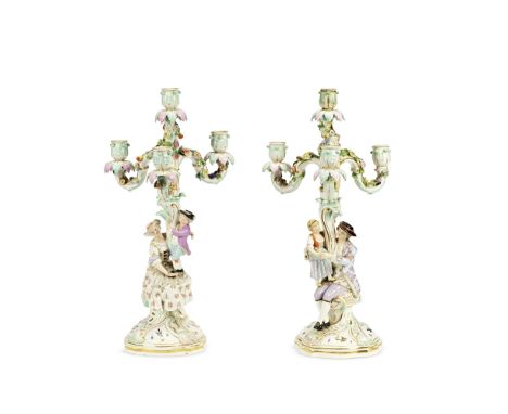 A pair of late 19th century Meissen porcelain figural four light candelabraformed as rustic groups in 18th century dress, one