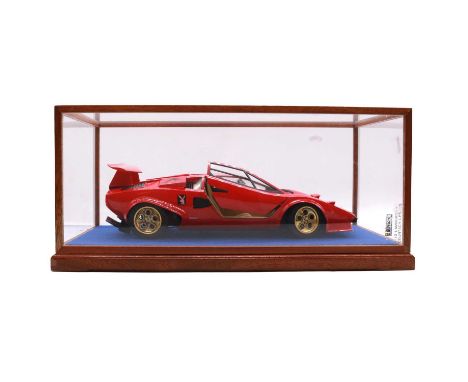 Two kit built model vehicles, including Lamborghini Countach and British racing green vehicle, both in display cases