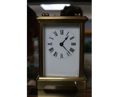 French Brass Carriage clock with panelled glass and Roman numeral dial 