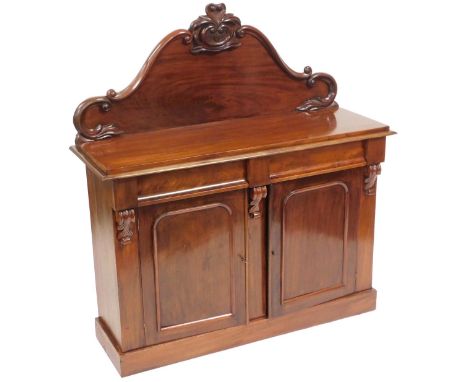 A Victorian mahogany chiffonier, with a foliate carved shaped back, above two cushion drawers, over a pair of doors, raised o