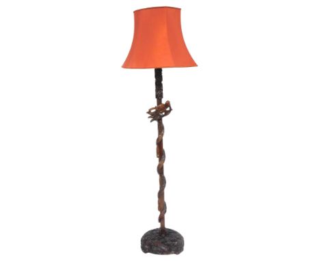 A Chinese hardwood standard lamp, carved with a dragon and clouds, with a red silk shade, 192cm high. Buyer Note: WARNING! Th