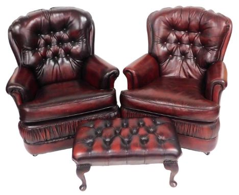 A pair of oxblood red leather armchairs, with button back, and loose cushion seats, 86cm wide, together with a red leather fo