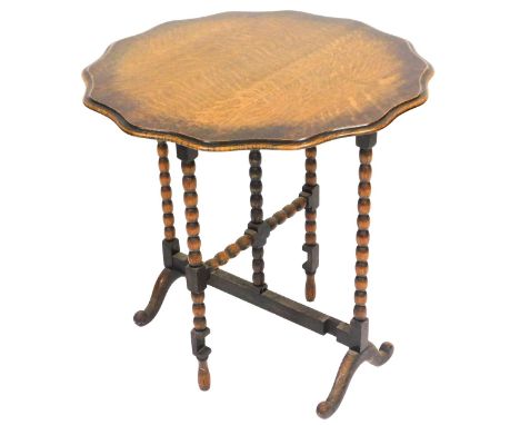 An early 20thC oak tilt top gate leg occasional table, raised on bobbin turned supports over cabriole legs, 71cm high x 72cm 