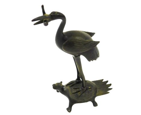 A Japanese bronze candlestick, modelled as a crane on a minogame mythical turtle with hairy tail, lacking candle sconce, 18cm