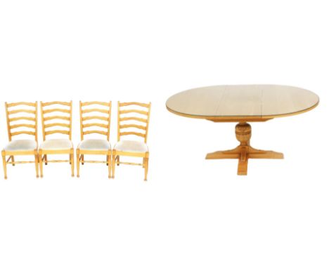 A Nathan light oak circular draw leaf dining table, with a glass top, raised on a leaf carved cup and cover supports above an