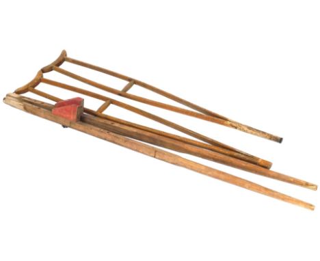 A pair of vintage wooden crutches, 127cm high, together with a pair of stilts, 148cm high. 