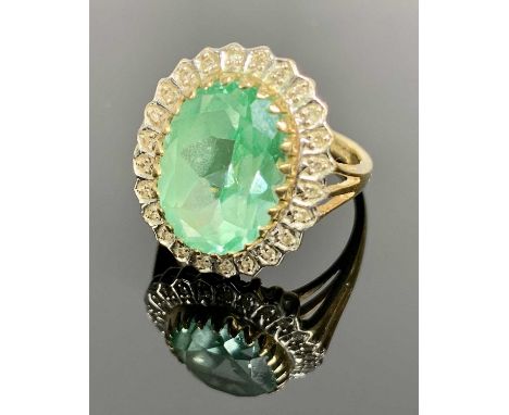 BROOKS &amp; BENTLEY 9CT GOLD DRESS RING - having a central 15 x 10mm facet cut oval, possibly topaz, surrounded by 24 small 