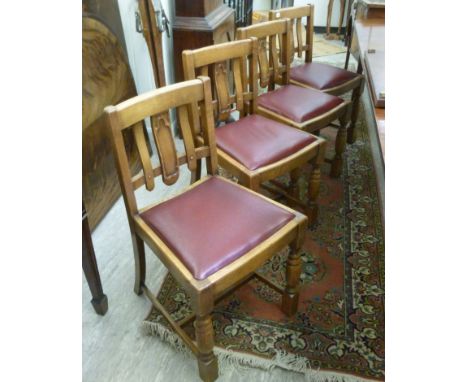 Four contemporary light oak, lath back dining chairs, the faux red hide drop-in seats raised on ring turned and block foreleg