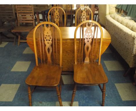 An Oak Drop Leaf Gate Leg Table and Four Wheel Back Chairs. 