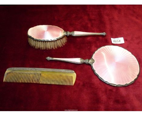 A Silver dressing table set including mirror, brush and comb, silver with engine turned enamelled pink handles and backing, B