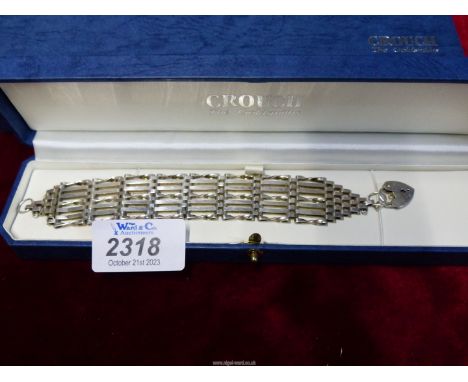 A Silver seven bar-gate Bracelet with silver locket, 7" long, maker H&M, in Crouch Jewellers box.