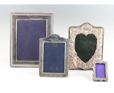 A collection of four silver fronted photograph frames, to include a miniature frame of scroll and cabochon design, hallmarked