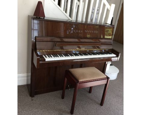 A Reiger-kloss upright piano, together with cushioned stool with storage and metronome.