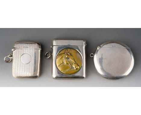 A George V engine turned silver vesta case, hallmarked HM., Birmingham, 1920; an Edwardian plain circular silver vesta case, 