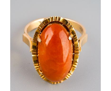 A jade dress ring, set with an oval orange jade cabochon, measuring approx 20.00 by 10.56mm (depth approx 6.56mm), four claw 