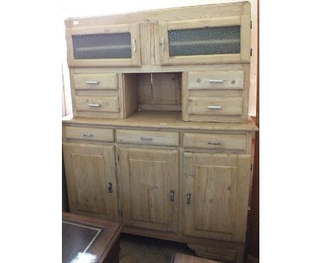 A substantial light pine kitchen larder with glazed doors, drawers and further cupboards below