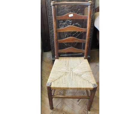 A pair of oak Arts and Crafts style ladder back chairs with string seats