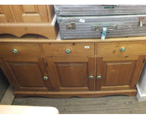A modern pine sideboard with ceramic knobs with three doors and three drawers