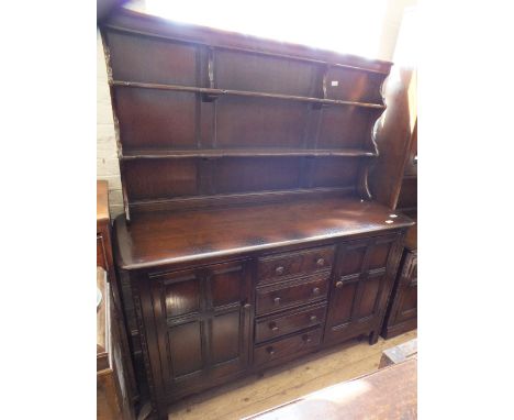 A dark Ercol shelf back sideboard with four drawers and two cupboards below