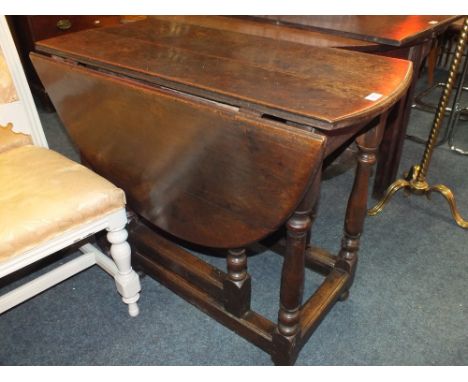 AN ANTIQUE OAK DROPLEAF TABLE, with typical gate leg mechanism, H 78 cm, Dia. 123 cm