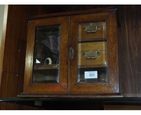 A VINTAGE OAK SMOKERS CABINET AND CONTENTS TO INCLUDE PIPES, LIGHTERS ETC