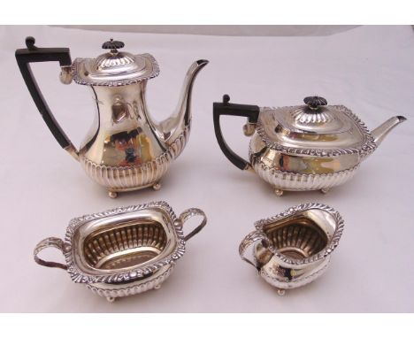 A hallmarked silver four piece tea and coffee set, rounded rectangular, part fluted with shell and gadrooned borders on ball 