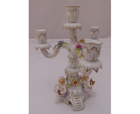 Schierholz porcelain four light candelabrum on triform base decorated with putti and applied flowers, marks to the base, 30.5