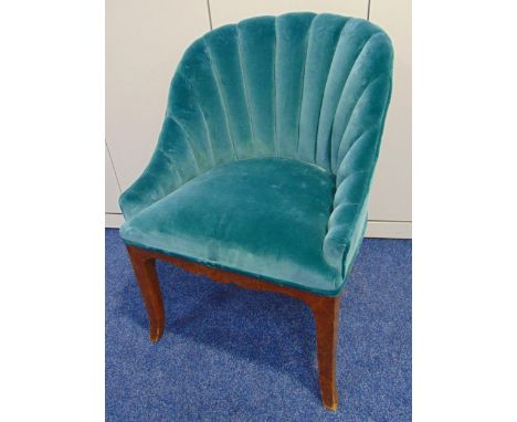 An Art Deco upholstered tub chair with fluted scalloped back on four outswept legs
