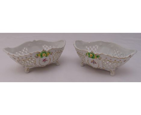 A pair of Sitzendorf porcelain oval pierced dishes on four scroll feet decorated with flowers and leaves, marks to the bases,