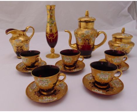 A Murano ruby red glass coffee set with over painted gilt decoration and applied porcelain flowers  to include a bud vase (14