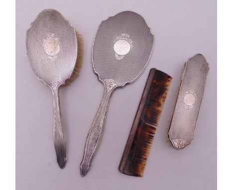 A hallmarked silver four piece dressing table set to include a hair brush, a clothes brush, a hand mirror and a comb