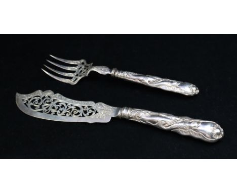 A pair of Victorian silver fish servers, both of ornate shape with pierced ends and filled handles with shell terminals and e