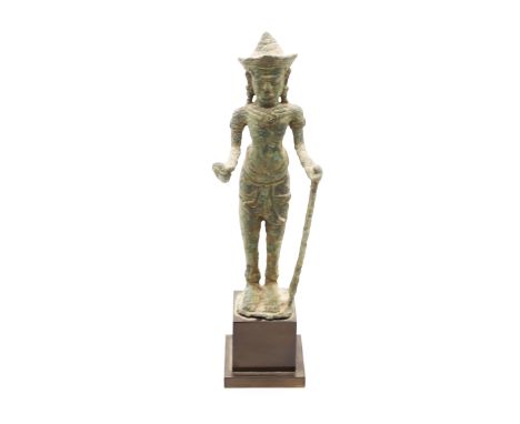 A Khmer bronze divinity, probably 12th century, holding a stick, approx. 19cm high.