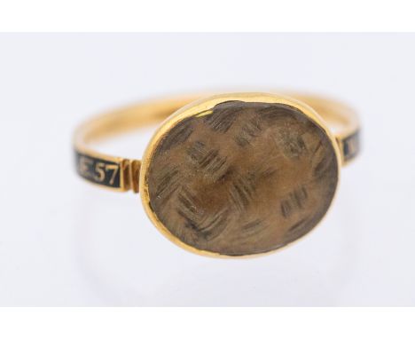A George III gold and black enamel and gold mourning ring - comprising an oval glazed compartment inset with plaited hair, wi