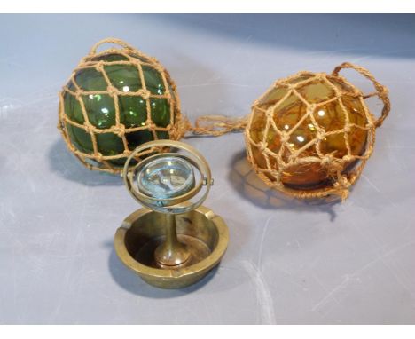Two antique fishing floats and a brass ship's compass ashtray. H14cm. 