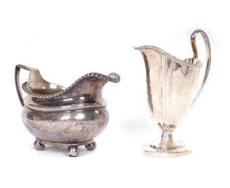 Two silver jugs. A George III silver oblong baluster-shaped cream jug, marks rubbed; together with an early 20th century helm