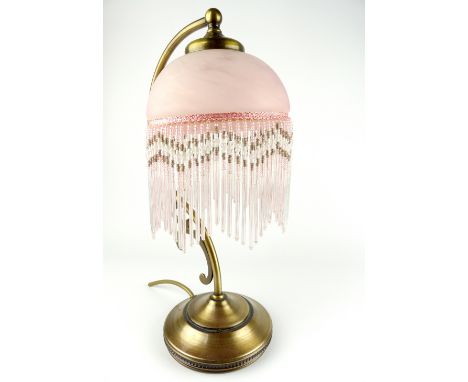 Art Nouveau style gilt metal table lamp with tasselled glass shade.