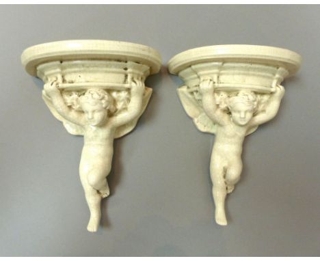 C. 1920s Sibley Pottery, Poole, England, matched pair of porcelain cream crackle glaze clock or wall brackets with putti supp