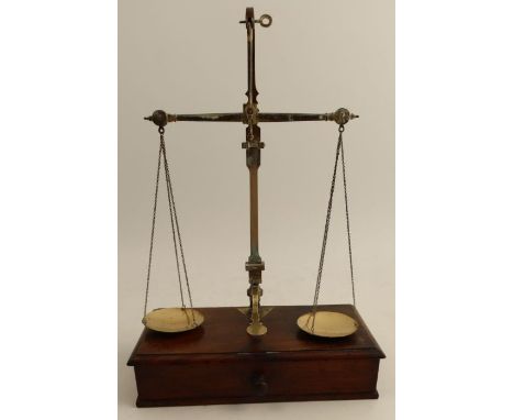A set of 19th century gilt metal pan scales, on a mahogany base fitted with a drawer, together with brass weights