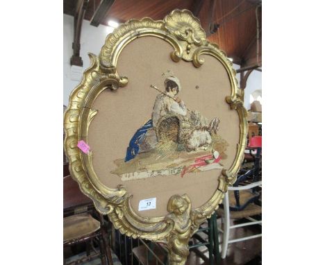 A gilt framed pole screen, having a tapestry of a boy and sheep raised on stylized reeded column terminating in three outswep